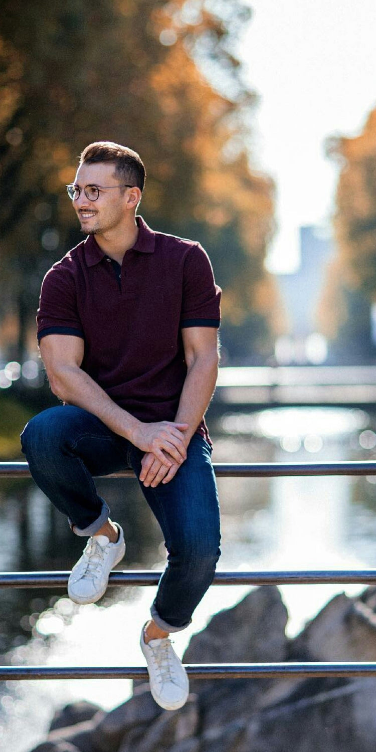 Maroon polo shirt + Indigo blue jeans + White sneakers